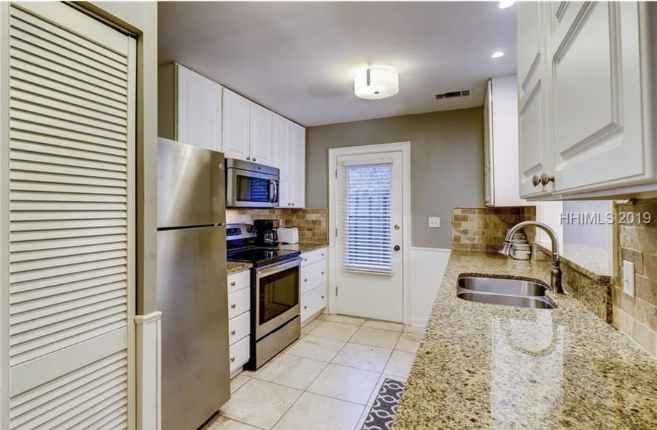 Kitchen door to outside trash/recycling, outdoor shower, beach/bike storage