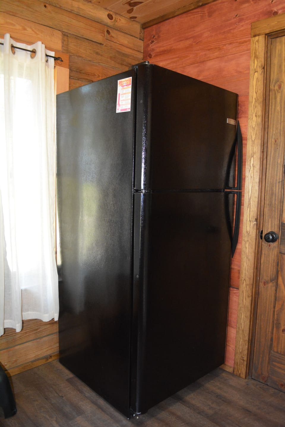 Utility room adjacent to kitchen includes refrigerator/freezer with ice maker.