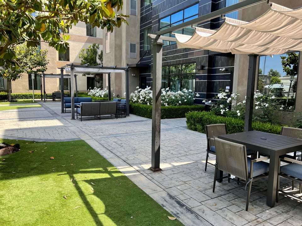 Inviting courtyard featuring comfortable seating areas and lush greenery.