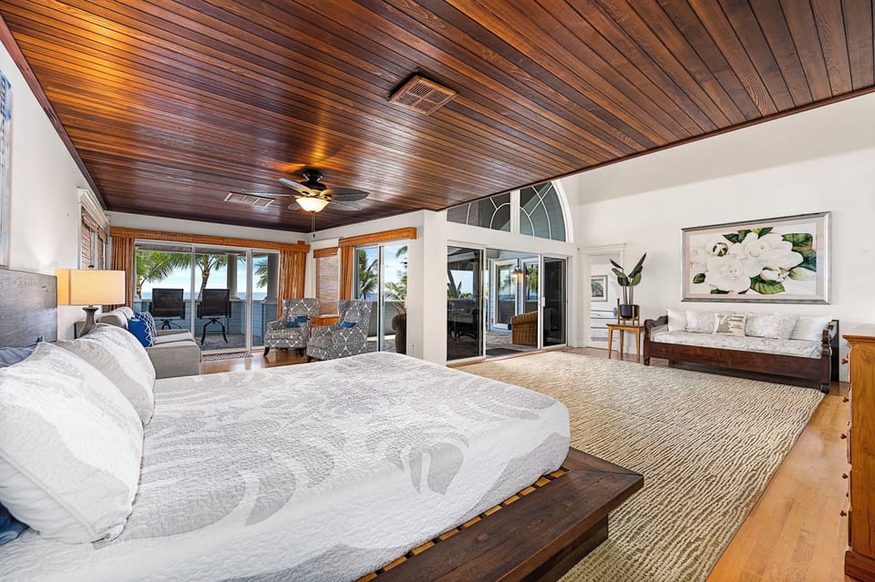 King bed in the primary suite with lanai access, central A/C, and flat-screen TV.