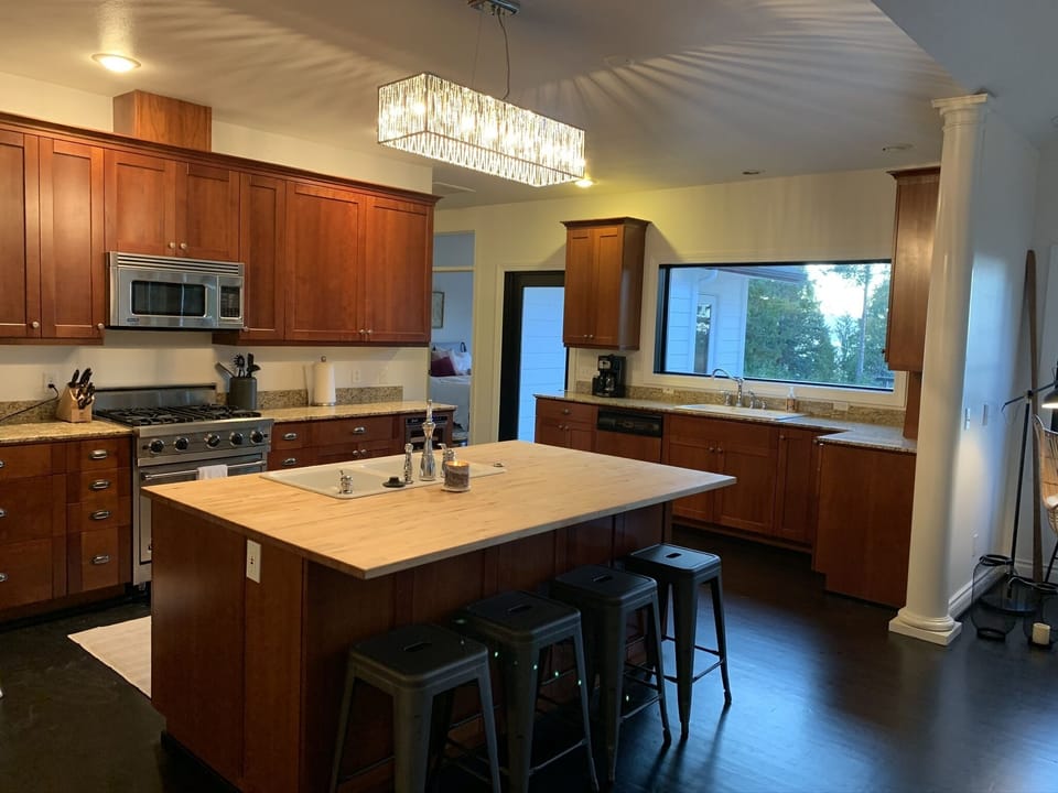 Large kitchen with Viking stove, 2 sinks, & seating at the island.