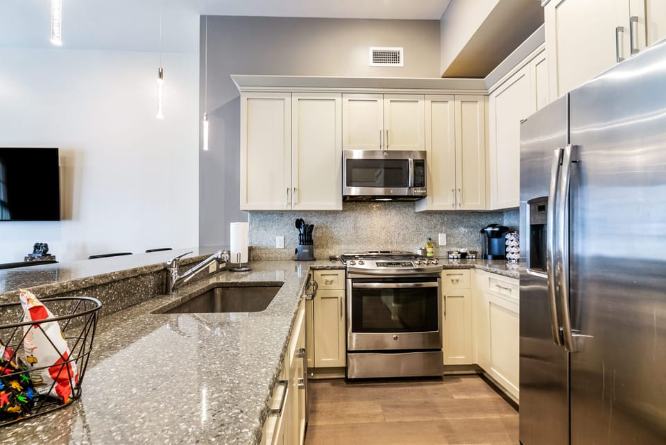 Cook and dine easily in the fully stocked kitchen, equipped with all stainless steel appliances, gas range, basic cookware, and a dining area for a comfortable meal at home. Entertain at the bar with seating for four.
