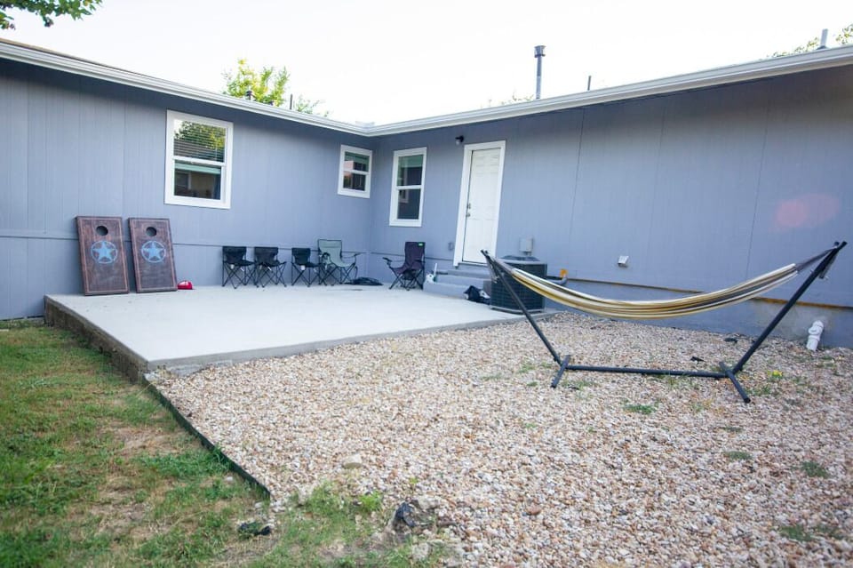 Relaxing patio with Hammock, Lawn Chairs, and Sack toss for backyard fun!