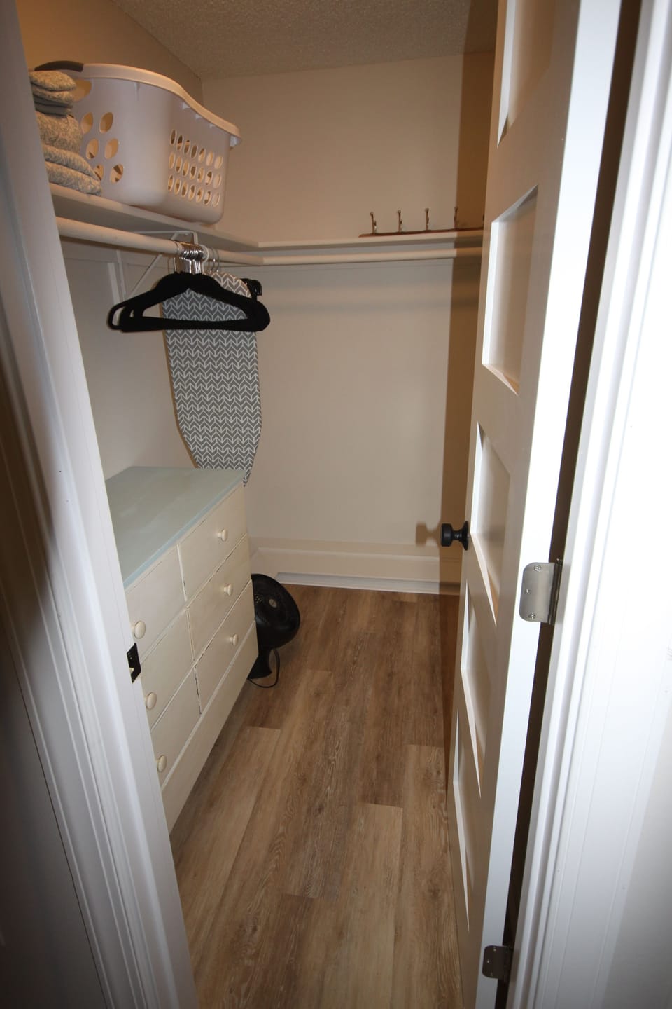 Master Bedroom Walk-in closet with built in dresser storage, iron board, iron.