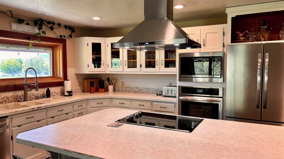 Cook in style with the sleek stove range and vent hood over the island.