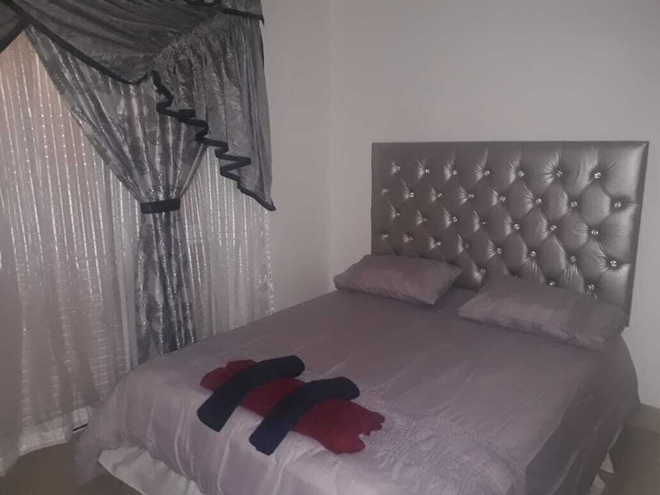 Bedroom 1 with queen size bed and built in cupboards. Sliding door into balcony.