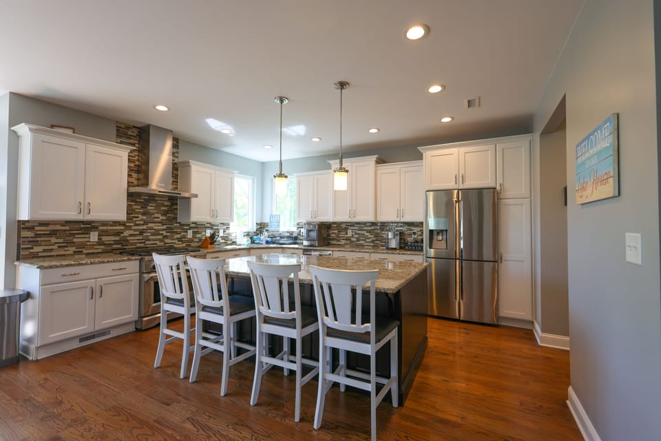 Kitchen with large island, 6 burner gas stove, microwave, and 4 door frig.  