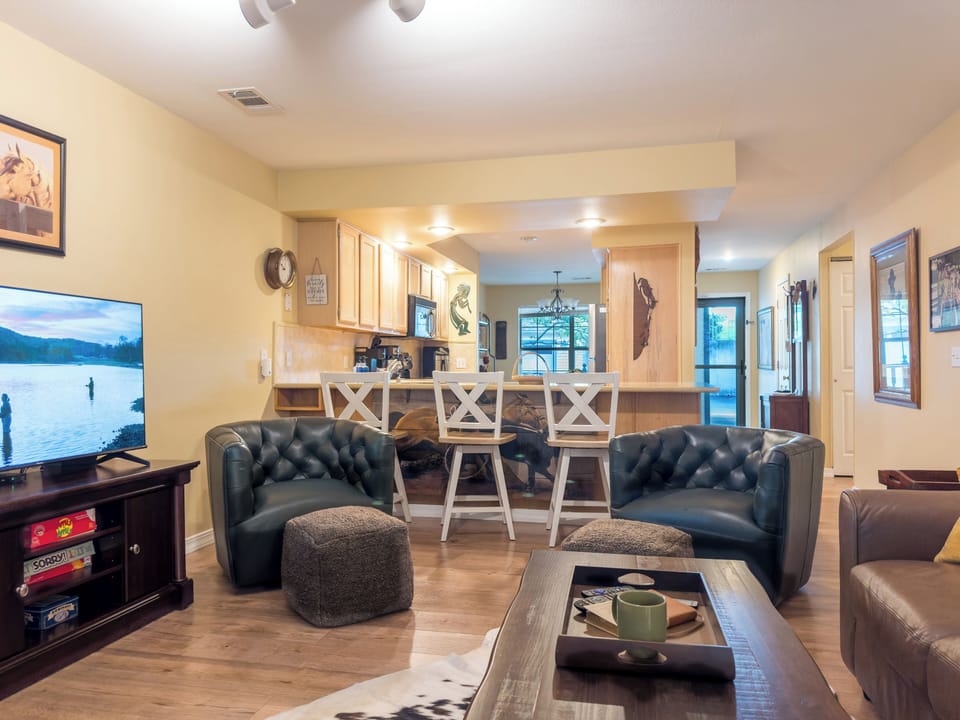 Enjoy this open-concept living space featuring comfy chairs and breakfast bar.
