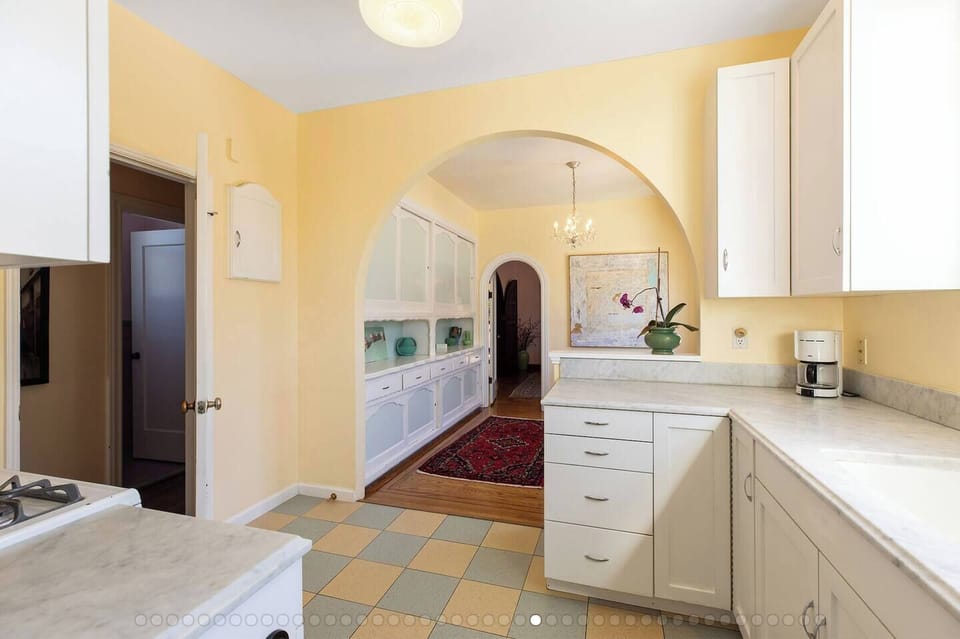 View from kitchen into breakfast area with small table for 2-4