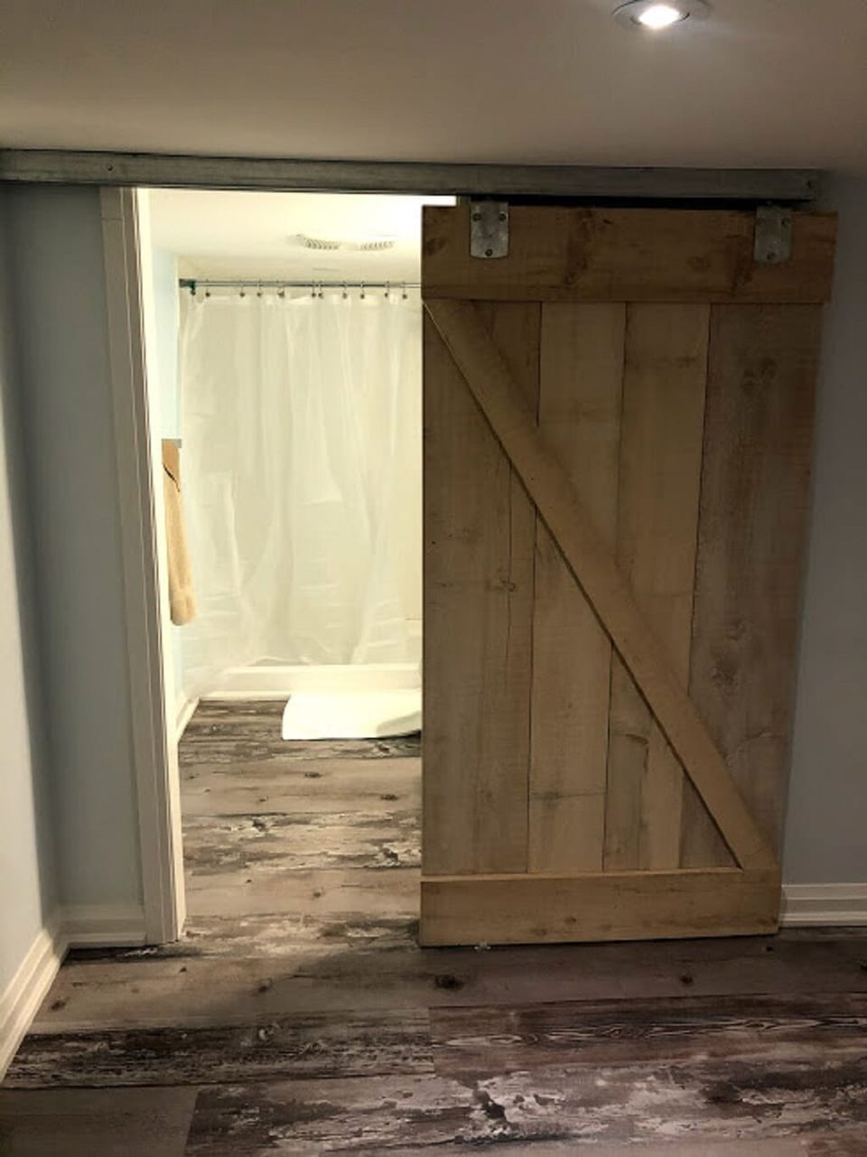 Sliding barn door to the bathroom, an elegant space saver. 