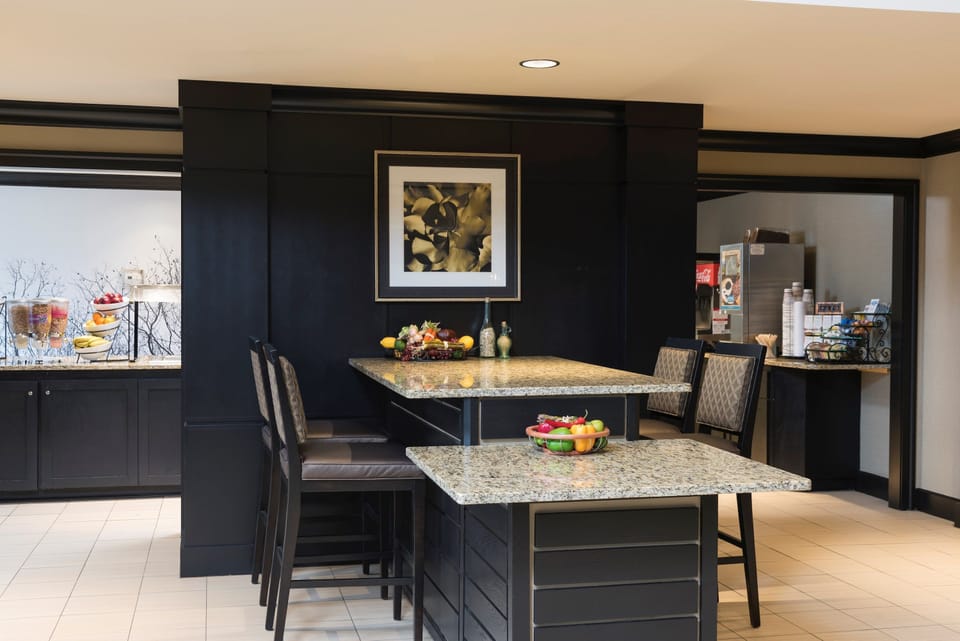 Bright breakfast dining area with tables and fresh fruit.