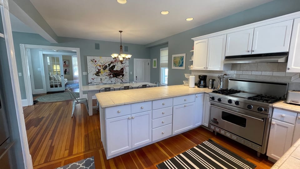 View of kitchen, Viking stove and dining room and entry foyer beyond.