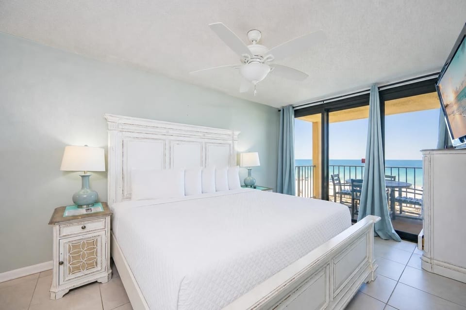 The master bedroom features a plush king bed, stylish nightstands, and a breathtaking view from the balcony