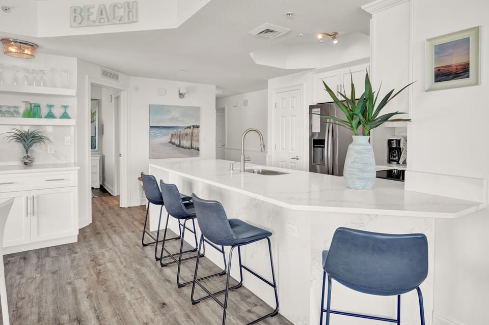 Your coastal-inspired kitchen awaits with marble countertops and ocean views, perfect for preparing meals while soaking in beach vibes.