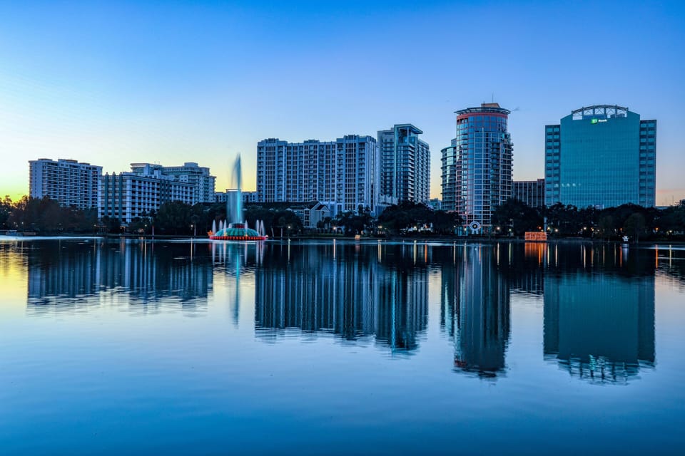 Reflected in the still surface of Lake Eola, Orlando's downtown skyline glows at dusk