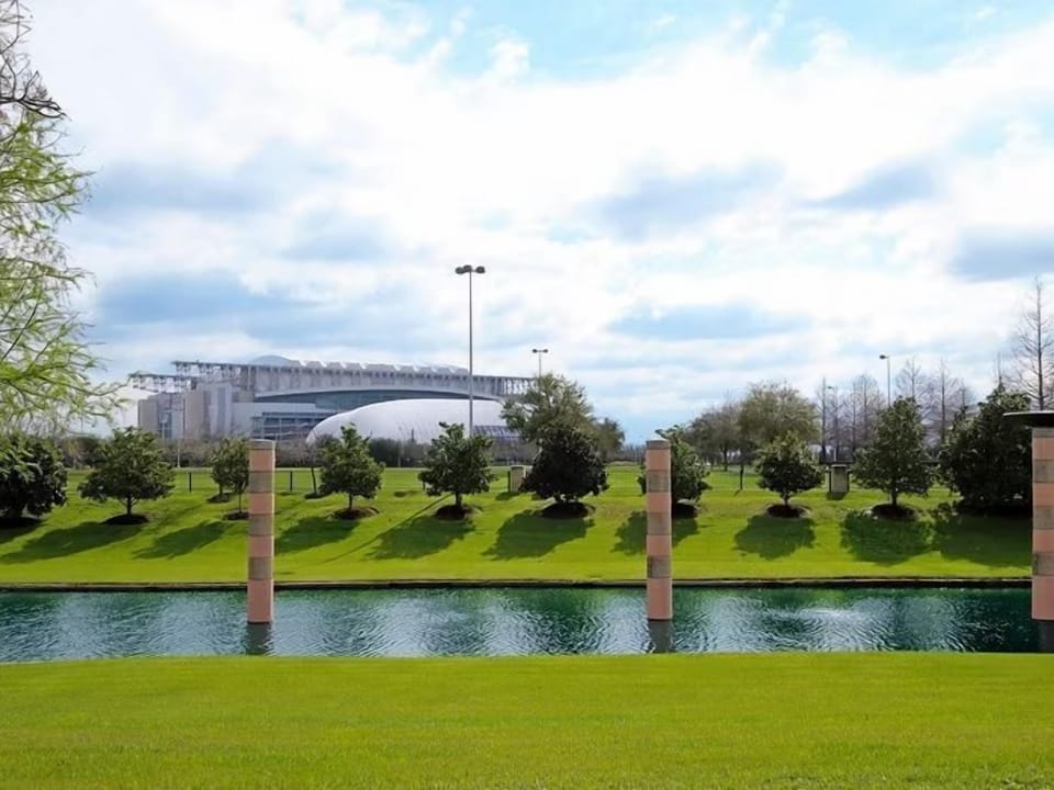 Lush green grounds with a serene water feature and open skies — a breath of fresh air right outside the hotel