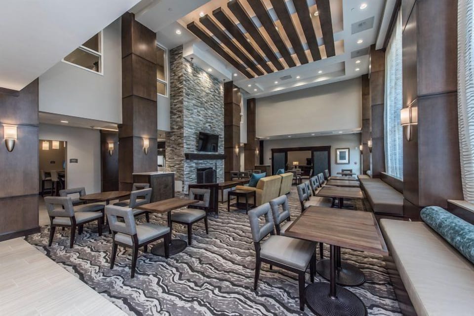 Gather in the grand lobby dining area with stone fireplace, high ceilings, and lounge seating.