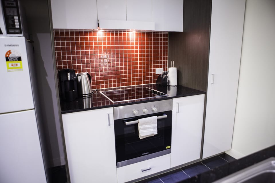 Kitchen with oven, fridge, microwave, kettle, stove top 