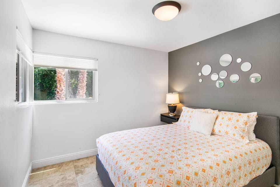 Bedroom 5 off the kitchen with a queen bed and views and access to backyard. 