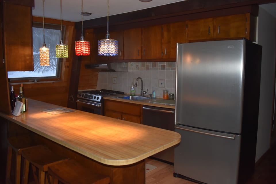 Open floor plan kitchen with counter and stools.