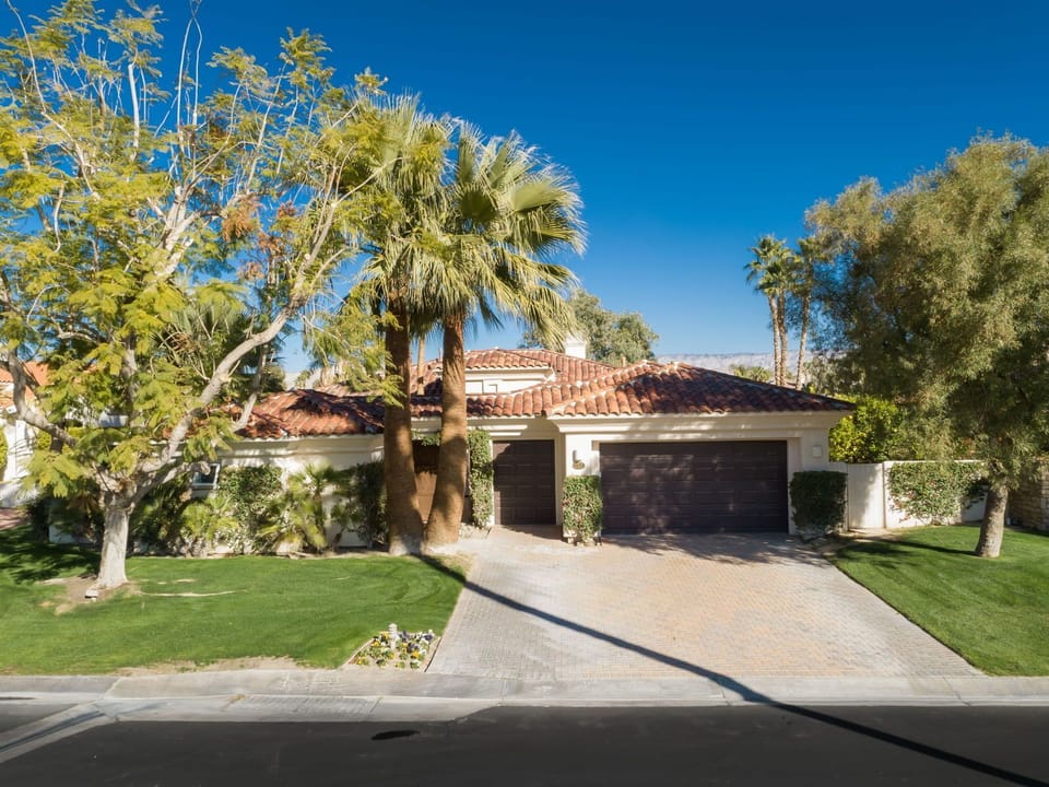 Front of home with mature landscaping.