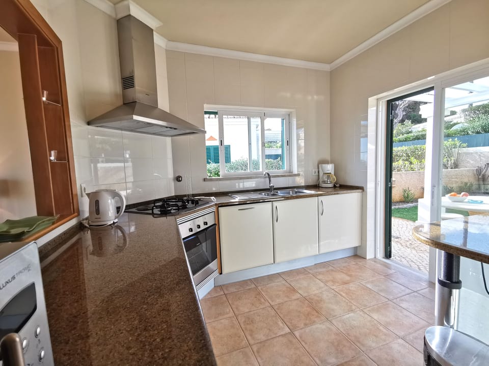 Bright well-equipped kitchen with door to terrace with seating 