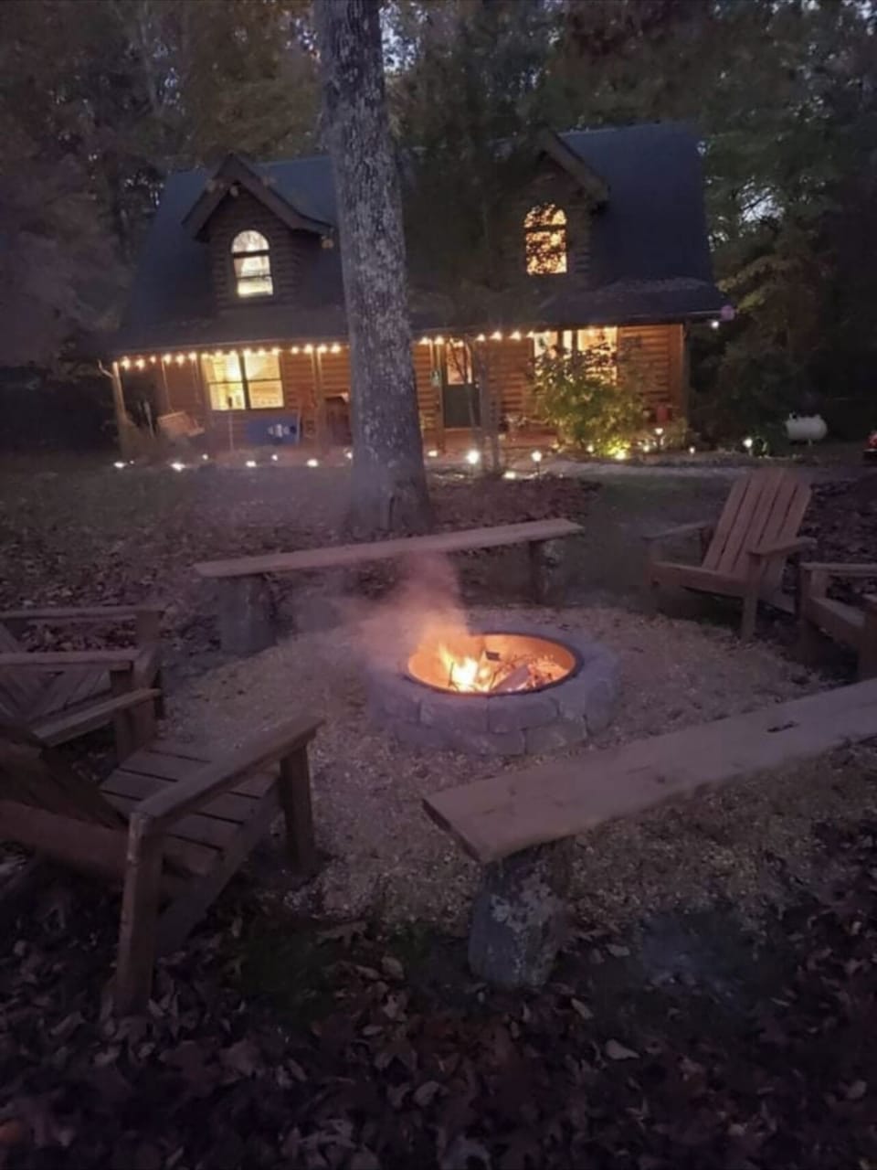Custom fire pit with view of the cabin at night 