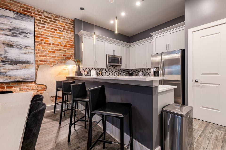 Cook and dine easily in the fully stocked kitchen, equipped with all stainless steel appliances, gas range, basic cookware, and a dining area for a comfortable meal at home.