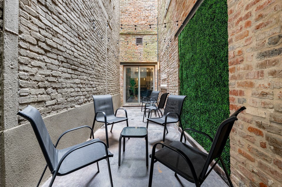Private patio with seating, string lights, and greenery