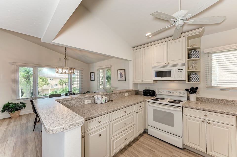 Kitchen has electric stove, microwave, and dish washer with open concept.
