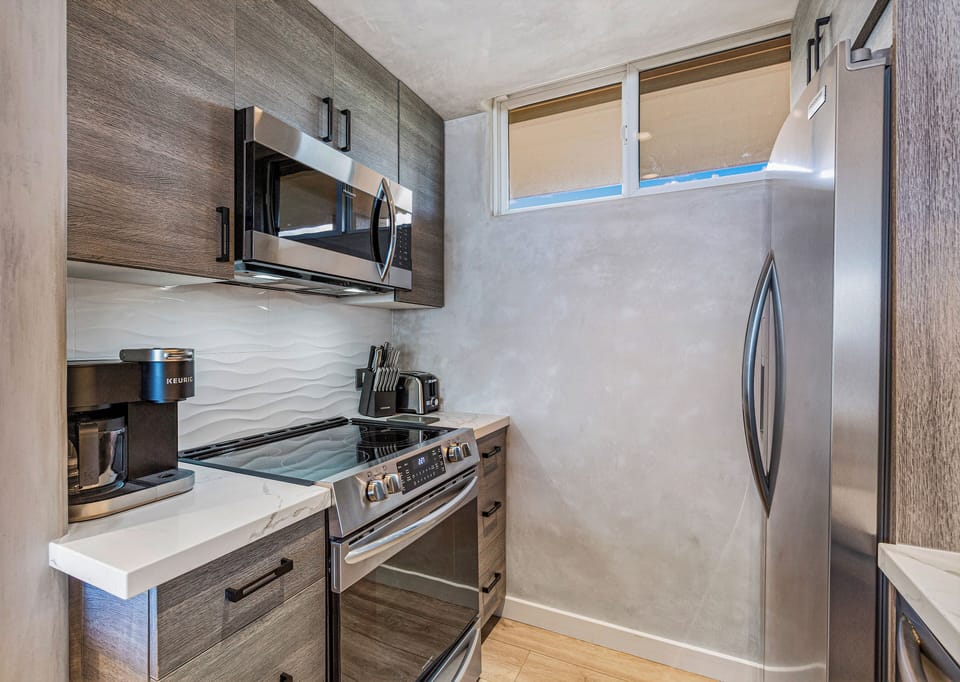 Cooking area with microwave, stove/oven, and coffee maker.