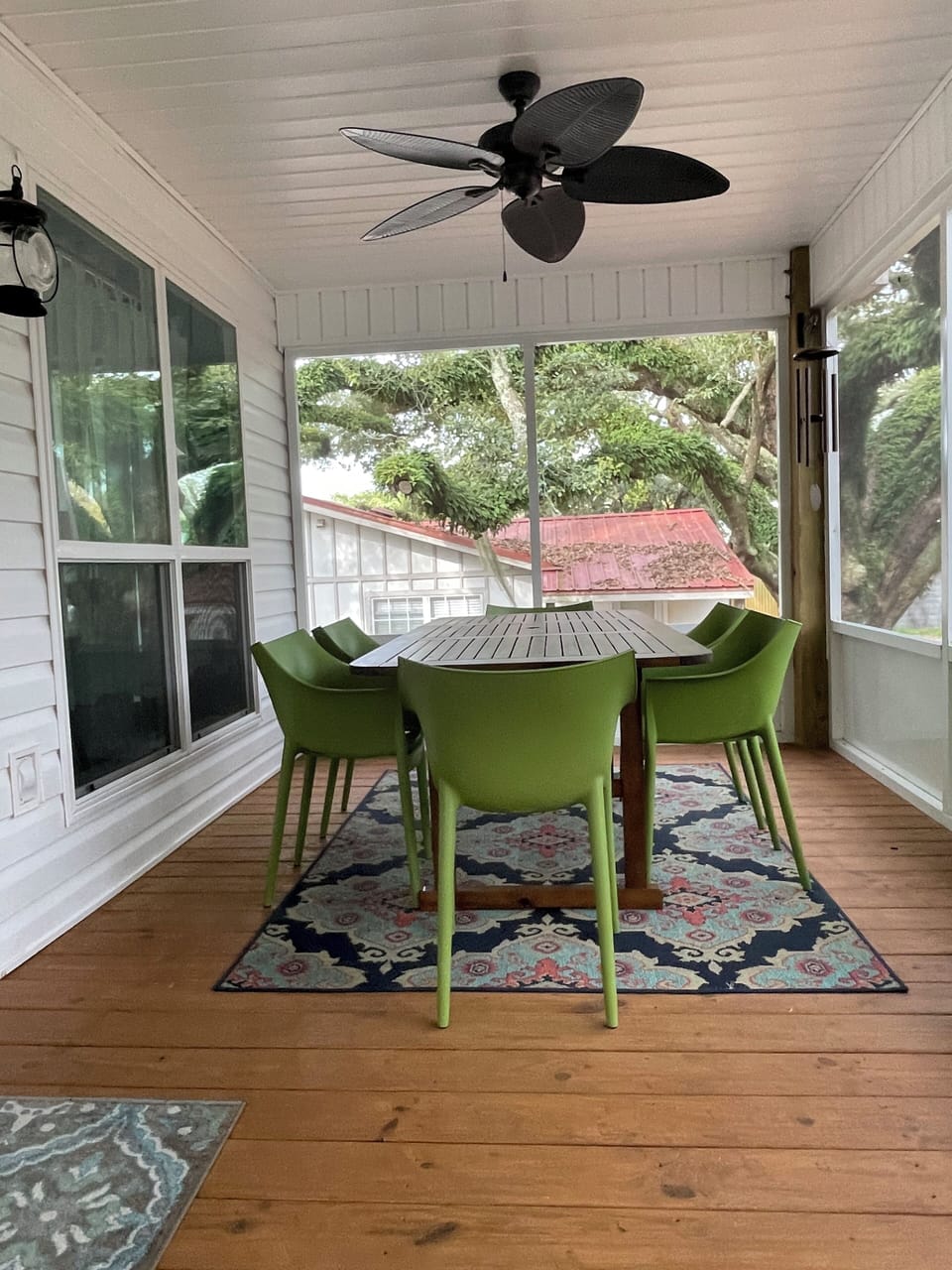 Nestled under heritage oak trees, back porch also features a teak table for six 