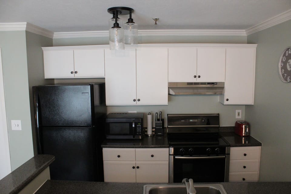 Kitchen with full size fridge, microwave, stovetop/oven, Keurig and dishwasher