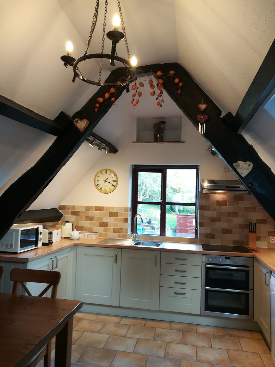 Welcoming and fully equipped kitchen, under the exposed beams and garden views