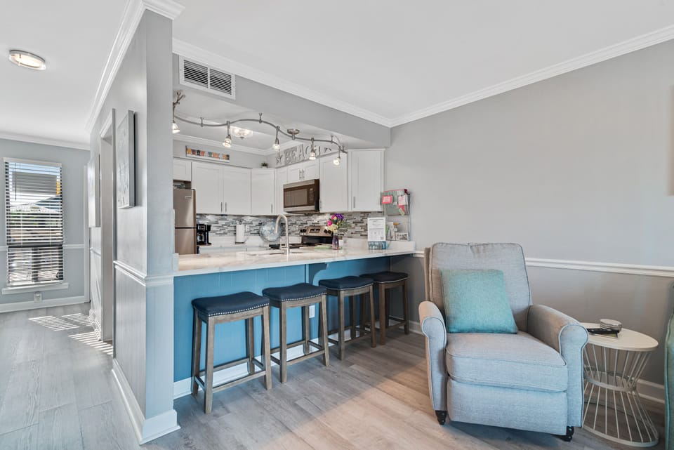 Thoughtful design creates a welcoming atmosphere in this kitchen nook, complete with comfortable bar stools and overhead lighting.