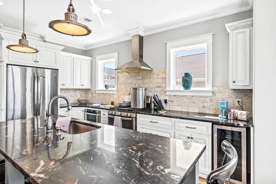 Fully stocked kitchen with stainless appliances, double ovens, microwave