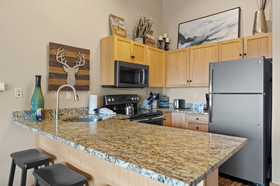 Full kitchen featuring stainless steel appliances, and breakfast bar for casual dining.