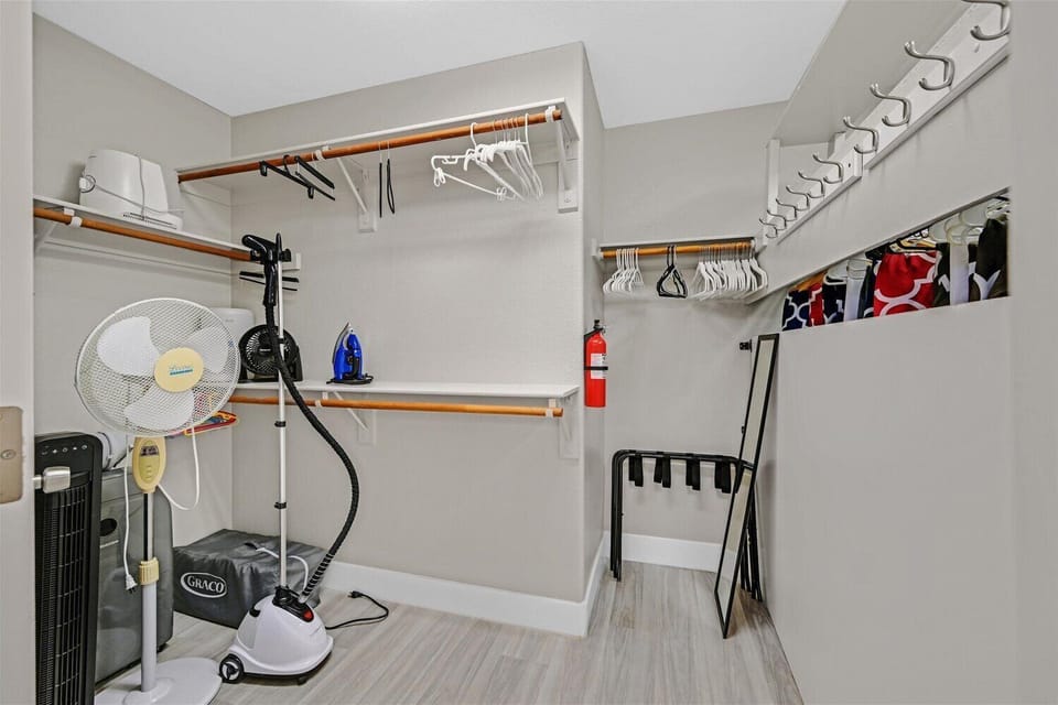 In primary closet. Floor fans, luggage rack, iron & board, steamer, hangers