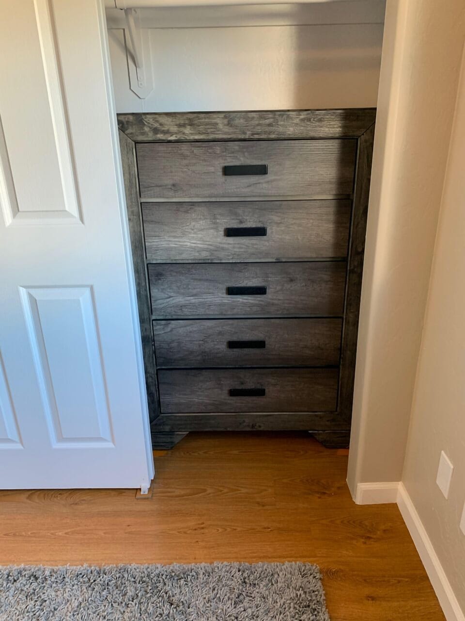 Full-sized 5 drawer dresser inside the closet, for storing additional clothing.