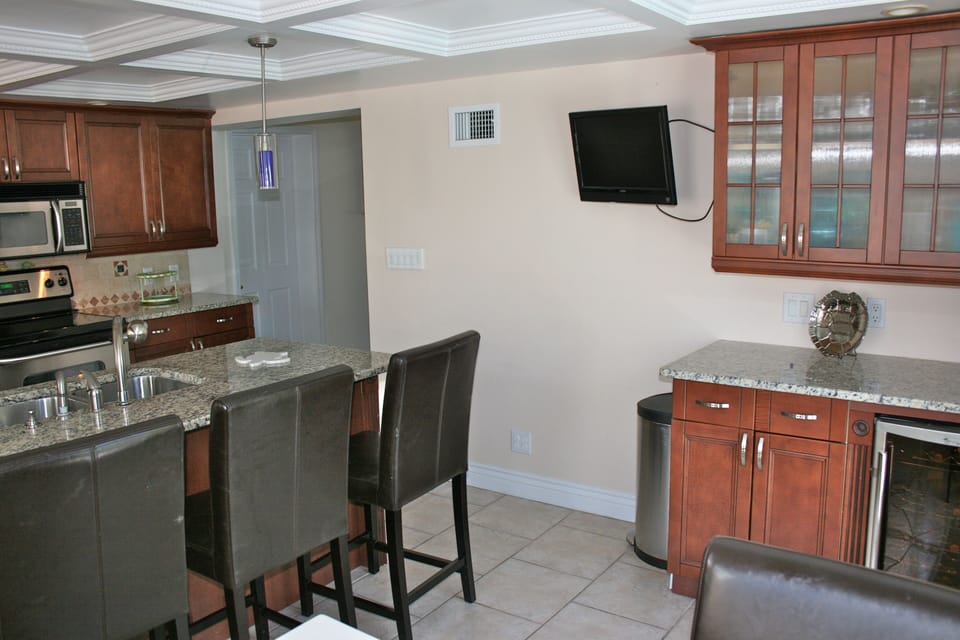 Kitchen with flat screen TV, wine cooler.