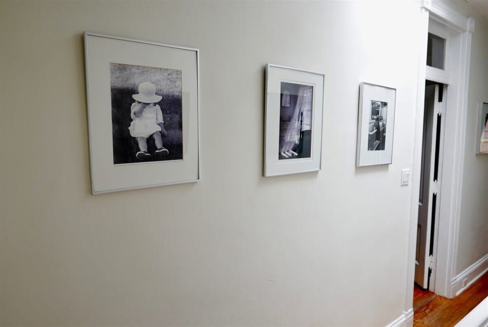 View of framed photographs adorning the hallway leading to the bedrooms