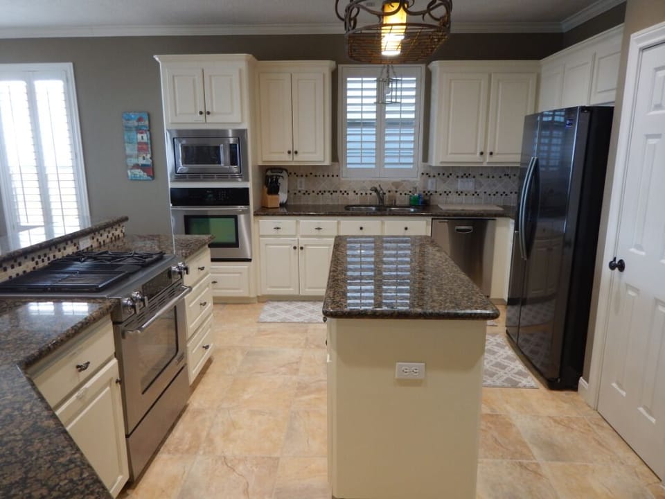 Kitchen is stocked with utensils, pots, pans, dishes, toaster, blender...