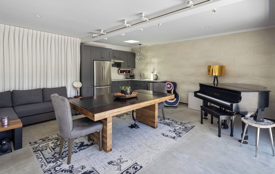 Private casita with kitchenette, baby grand piano, workspace, TV and sofa.