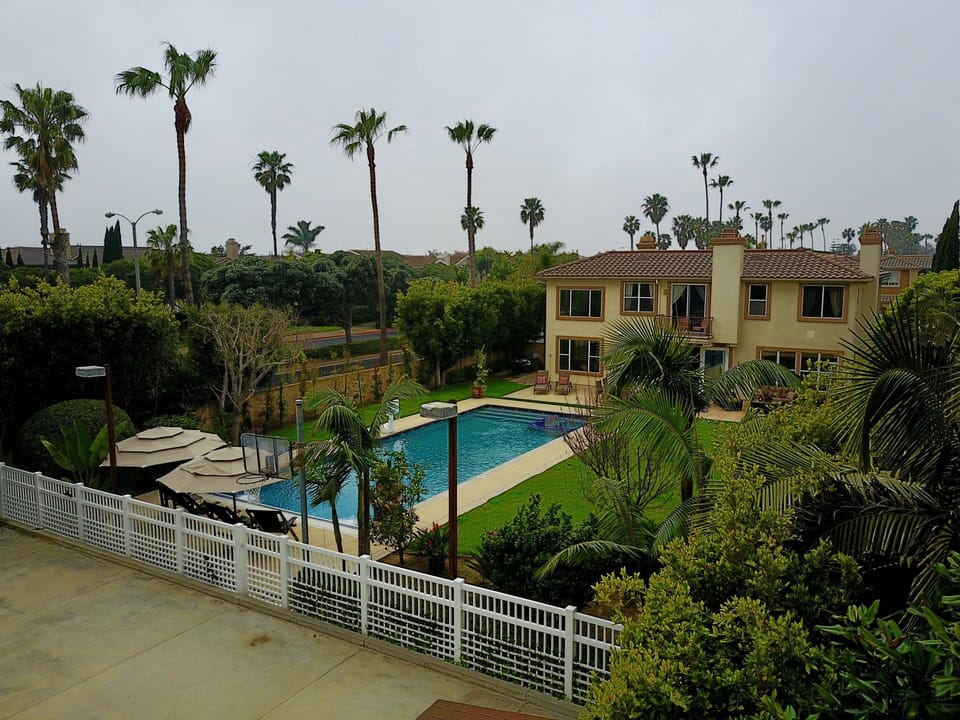 Backyard with sport court, lawn and pool area