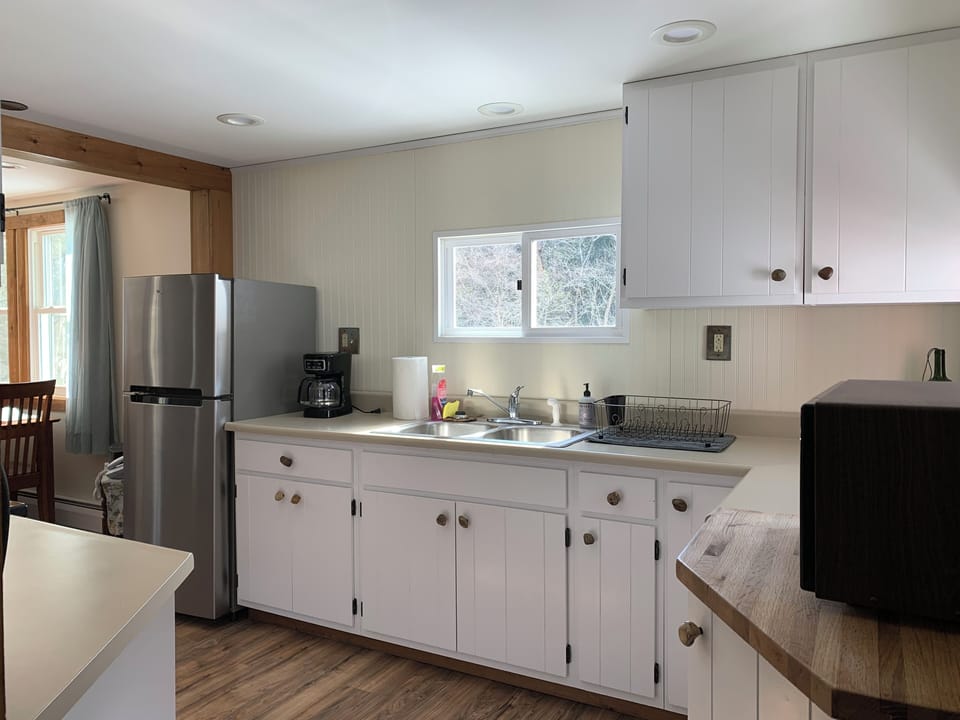Kitchen w/ gas stove/oven, microwave, coffee maker, and lots of pots & pans.