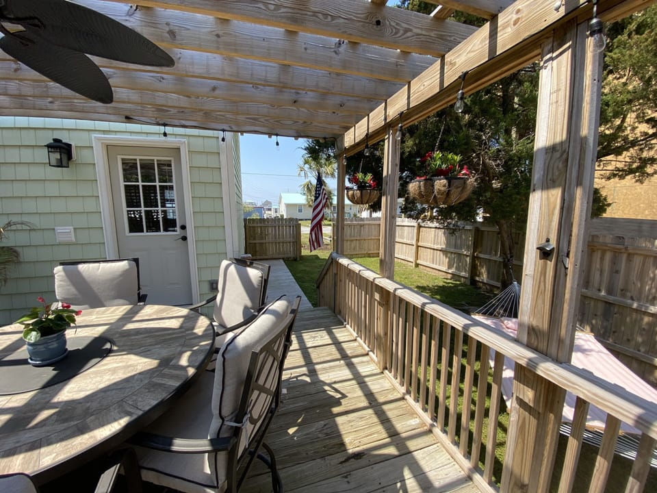Private pergola deck with access to yard, hammock, outdoor shower.