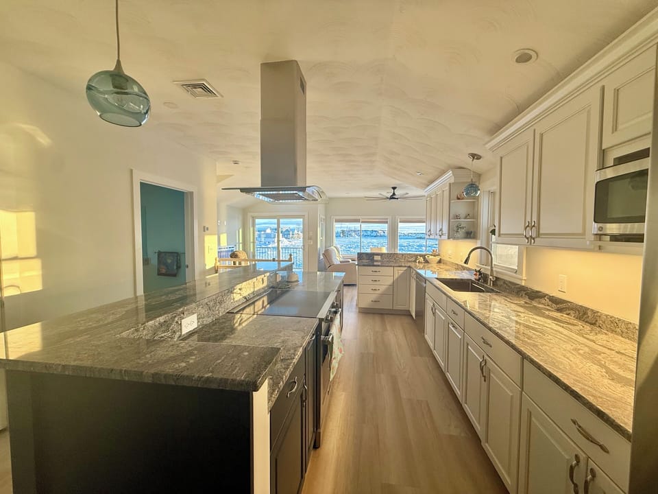 Full kitchen with stainless steel appliances, induction stove and bar seating