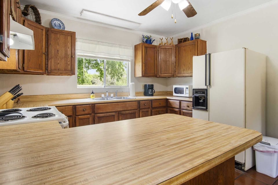 Spacious kitchen with ample counter space, vintage charm, and a serene view for a peaceful cooking experience.