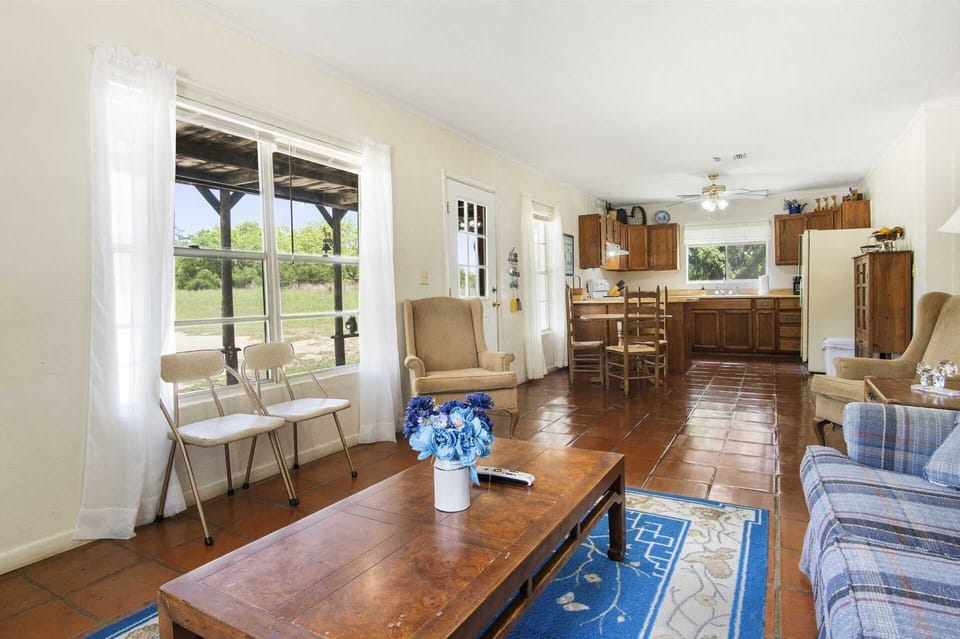 Open-concept living and kitchen area with natural light, rustic charm, and cozy seating-perfect for family gatherings or relaxing.