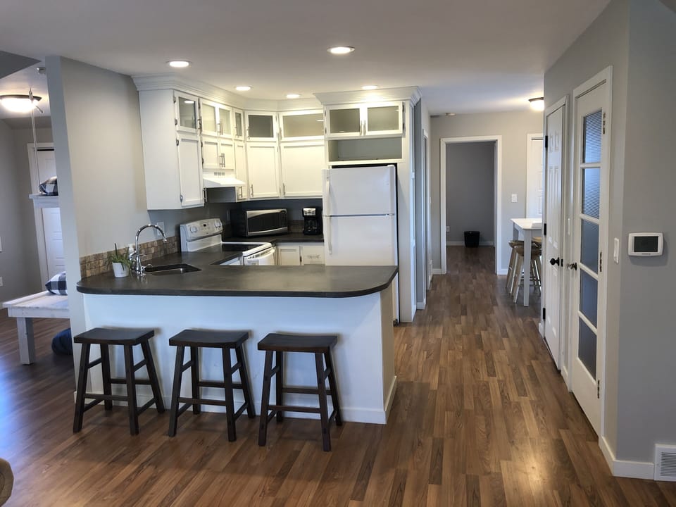 Fully equipped kitchen with 3 bar stools for extra seating.
